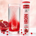 Iron Fizz tablet dissolving in a glass of water beside the tube